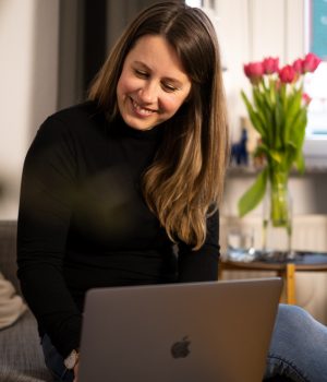 Janina3 Kopie Business Coach sitzt vor Laptop und unterstützt Kunden bei der richtigen Entscheidung.